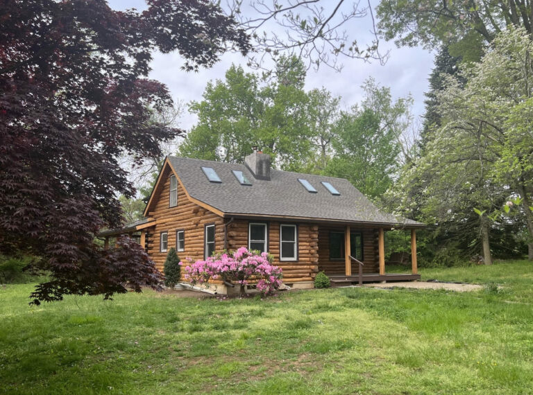 Log cabin home with new shingle roof.