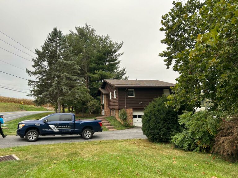 A brown house with a brand new GAF Barkwood roof with an MKS Construction pickup truck outside